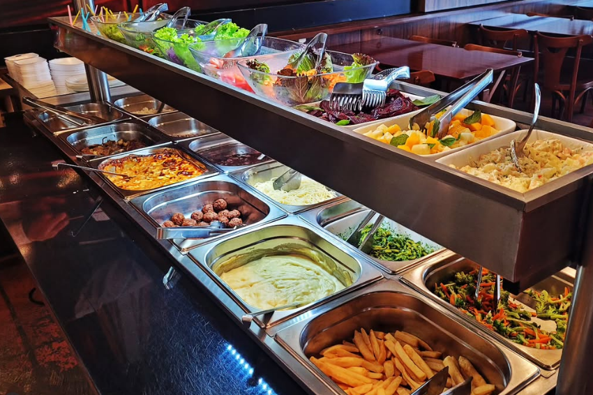 Buffet com saladas, carnes, massas e acompanhamentos